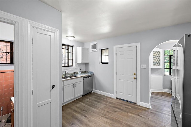 kitchen with a wealth of natural light, dishwasher, light hardwood / wood-style floors, and white cabinets