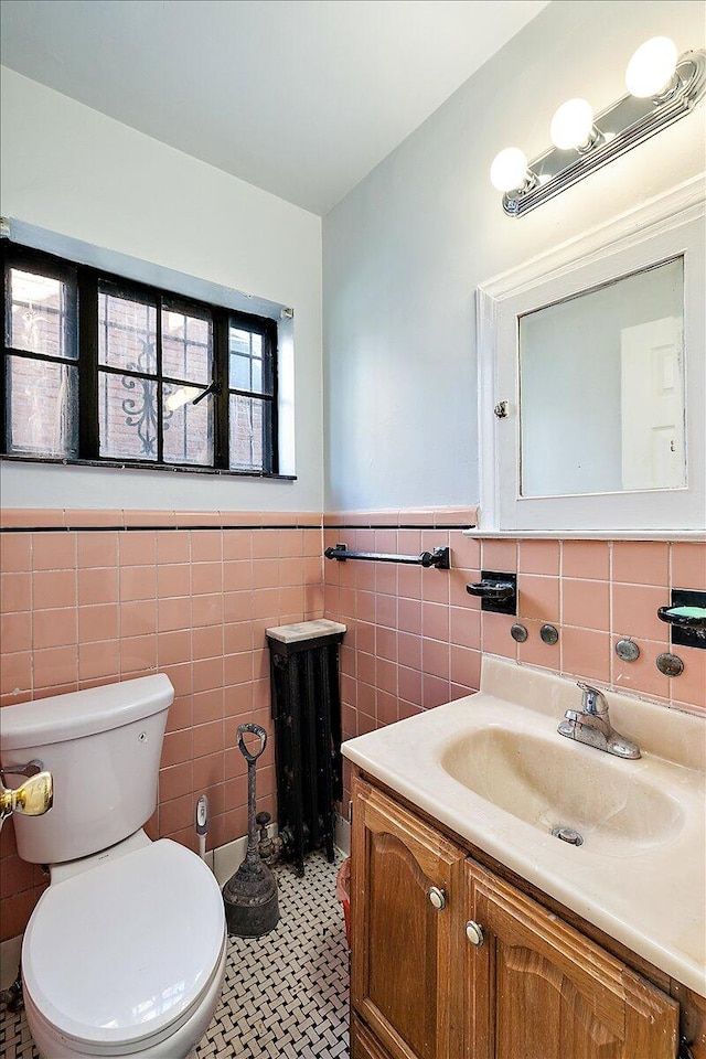 bathroom with tile walls, vanity, toilet, and tile patterned floors