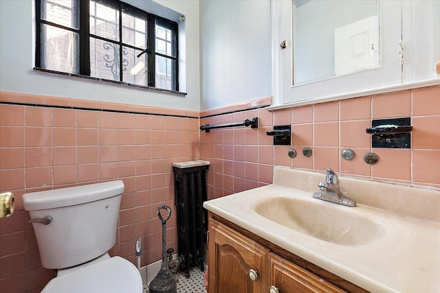 bathroom with tile walls, vanity, and toilet