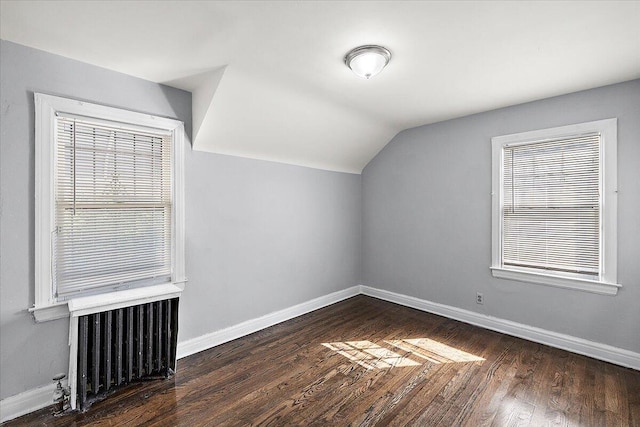 additional living space with lofted ceiling, radiator, and dark hardwood / wood-style floors