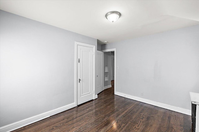 unfurnished room with dark hardwood / wood-style flooring