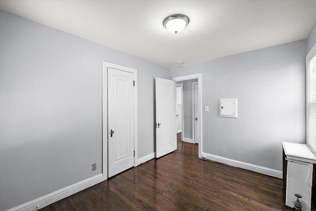 unfurnished bedroom featuring dark wood-type flooring and a closet