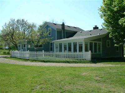 rear view of house featuring a sunroom and a yard