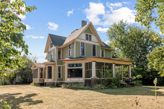 view of front of home with a sunroom and a front yard