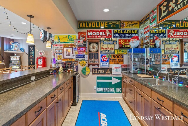 bar with beverage cooler, hanging light fixtures, light tile patterned flooring, and sink