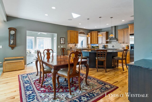 dining area featuring light wood-type flooring, a healthy amount of sunlight, and ceiling fan