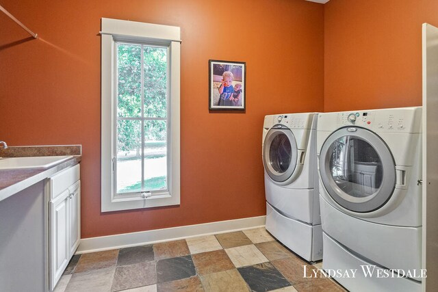 washroom with cabinets, sink, and washer and dryer