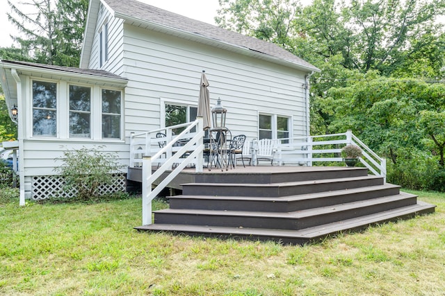 rear view of property with a wooden deck and a yard