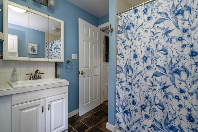 bathroom featuring decorative backsplash, walk in shower, and vanity