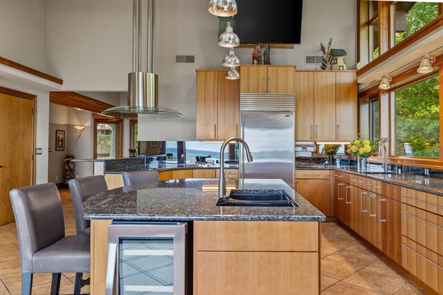 kitchen with pendant lighting, beverage cooler, a towering ceiling, and a wealth of natural light