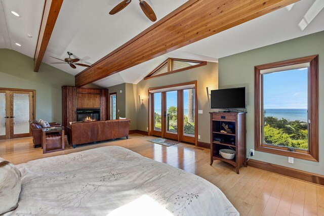 bedroom featuring access to outside, light hardwood / wood-style flooring, vaulted ceiling with beams, ceiling fan, and french doors