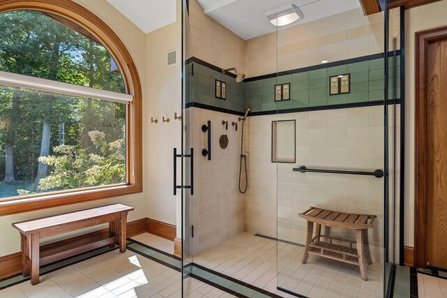 bathroom featuring tile patterned flooring, a shower with door, and plenty of natural light