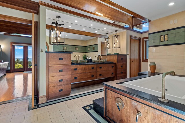 kitchen with tile walls, light hardwood / wood-style floors, sink, and decorative light fixtures