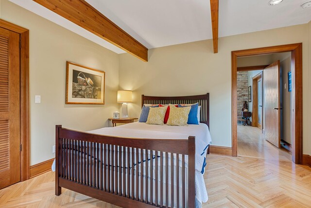 bedroom with beam ceiling and light parquet floors