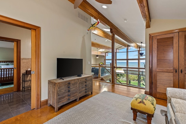 tiled living room featuring ceiling fan and lofted ceiling with beams