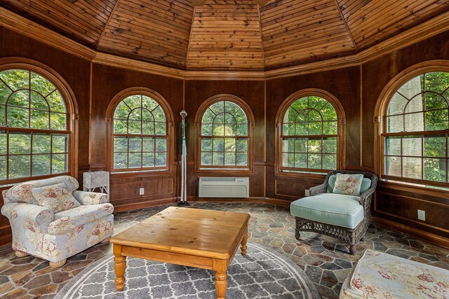 sitting room with a wealth of natural light, wood walls, a wall unit AC, and wooden ceiling