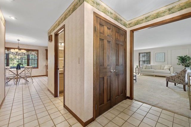 entryway featuring a chandelier and light colored carpet