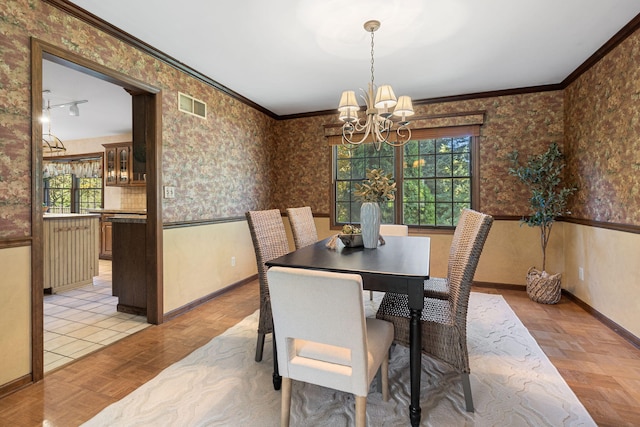 dining room with ceiling fan with notable chandelier, crown molding, light parquet flooring, and a wealth of natural light