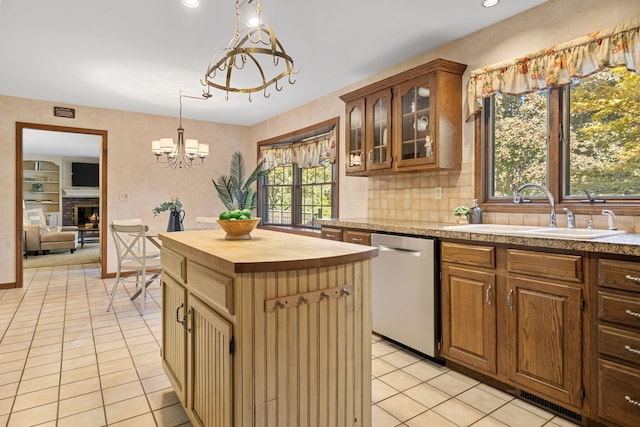 kitchen featuring a notable chandelier, dishwasher, a kitchen island, and a healthy amount of sunlight