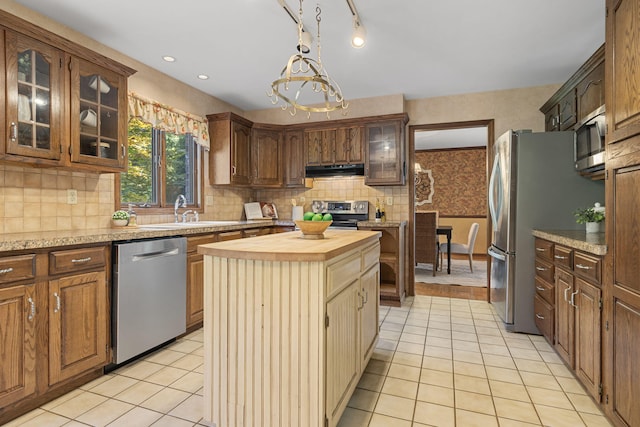 kitchen featuring a chandelier, sink, a kitchen island, appliances with stainless steel finishes, and wooden counters