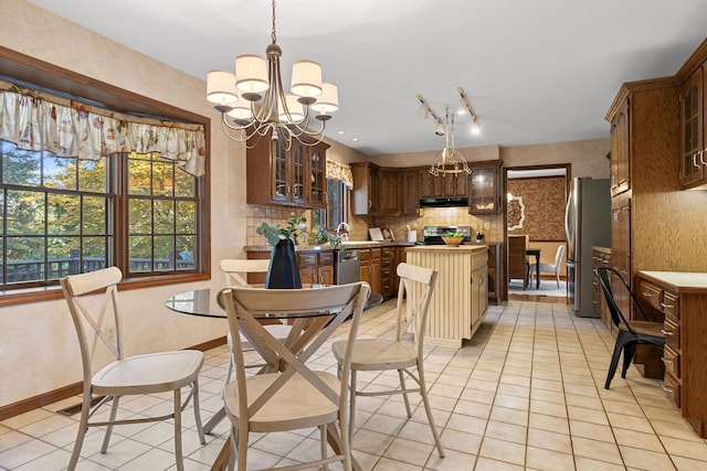 interior space featuring appliances with stainless steel finishes, hanging light fixtures, light tile patterned floors, and a notable chandelier