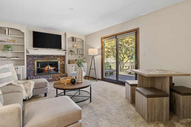 carpeted living room featuring built in shelves and a brick fireplace