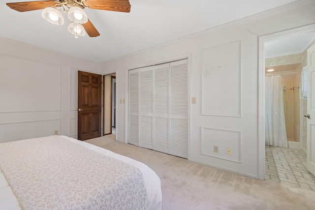 carpeted bedroom featuring crown molding, ceiling fan, and a closet