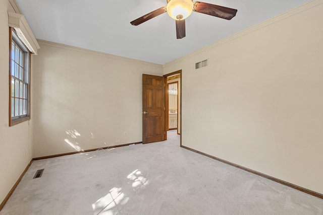 unfurnished room with ornamental molding, ceiling fan, and light colored carpet