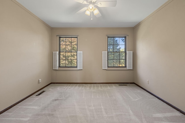 empty room with ceiling fan, light colored carpet, and plenty of natural light