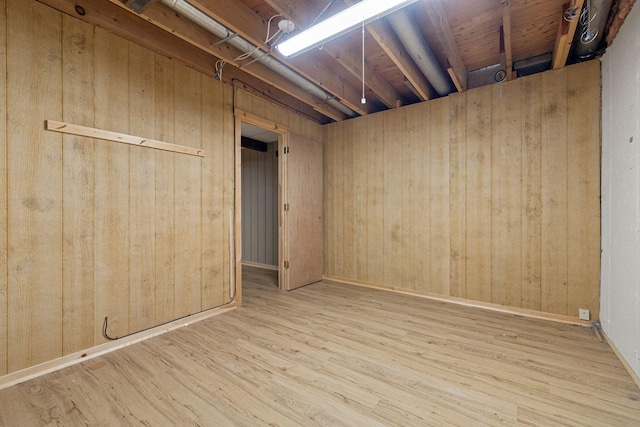 basement featuring wood-type flooring and wooden walls