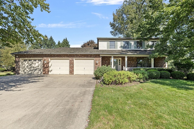 view of property featuring a front yard, a garage, and a porch