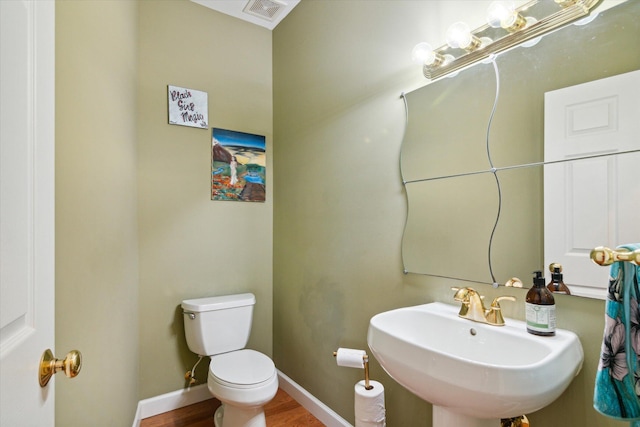 bathroom with toilet, sink, and hardwood / wood-style floors