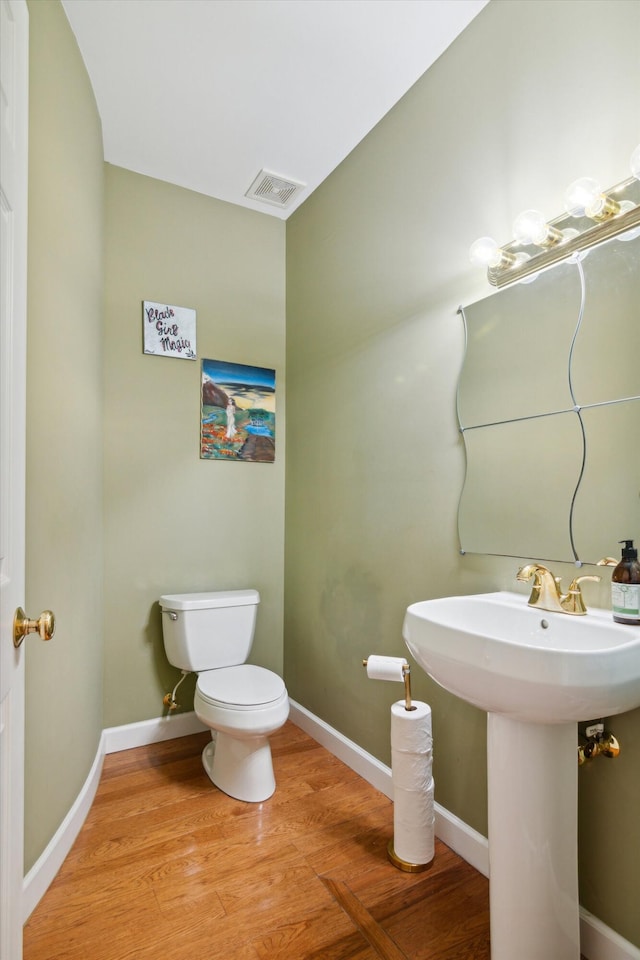 bathroom featuring toilet, wood-type flooring, and sink