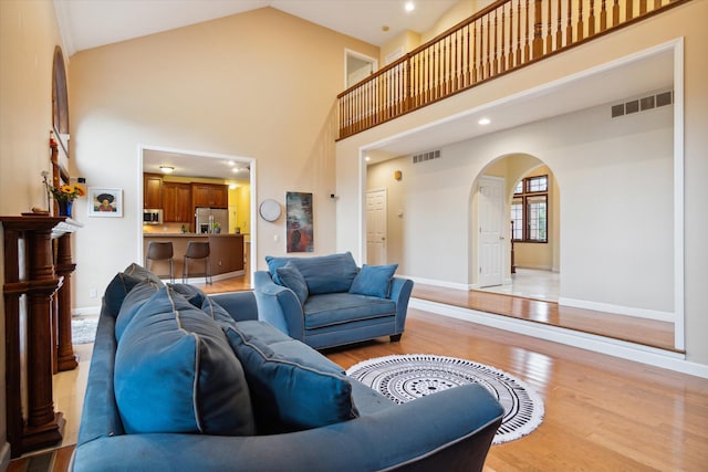 living room featuring light hardwood / wood-style flooring and high vaulted ceiling