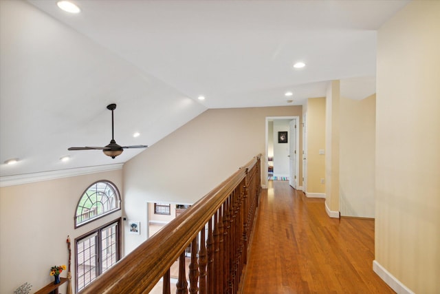 corridor with light hardwood / wood-style flooring and vaulted ceiling