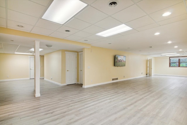 basement featuring light hardwood / wood-style flooring and a paneled ceiling