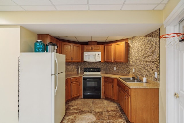 kitchen featuring a paneled ceiling, sink, and white appliances