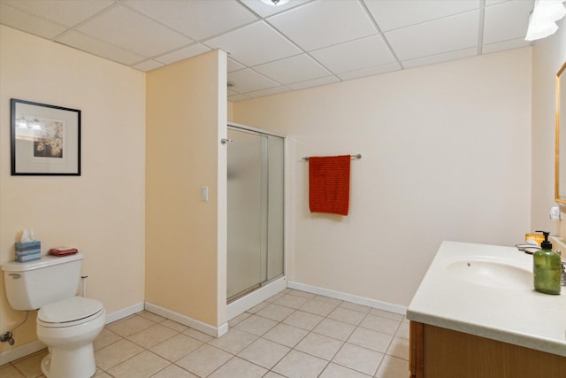 bathroom with toilet, vanity, a paneled ceiling, and a shower with door