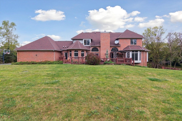 rear view of property featuring a wooden deck and a yard