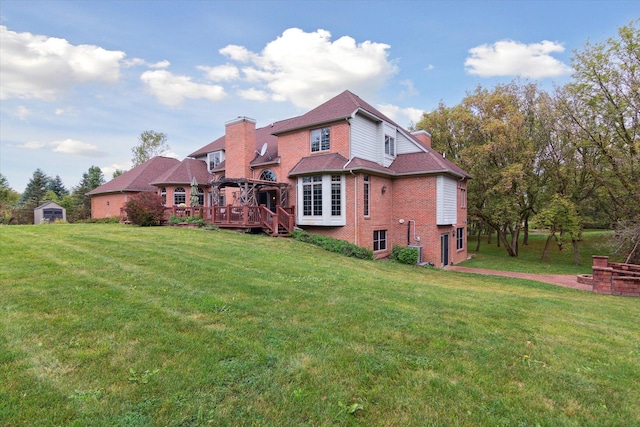 rear view of property with a wooden deck and a yard