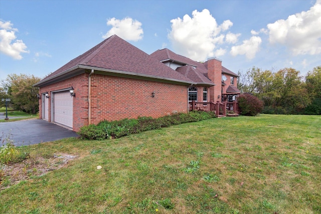 view of side of home with a deck, a yard, and a garage