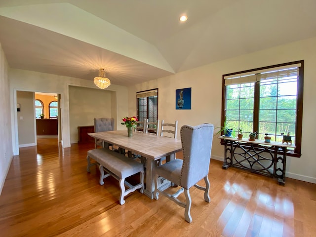 dining room with vaulted ceiling, light hardwood / wood-style flooring, and a notable chandelier