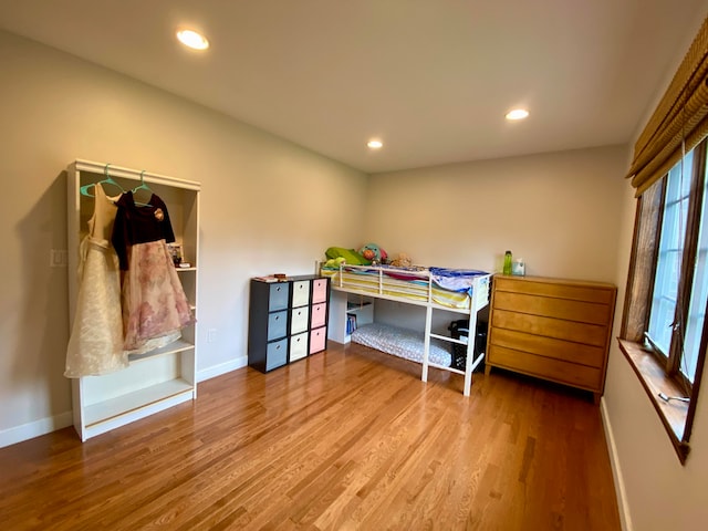 bedroom with wood-type flooring and multiple windows