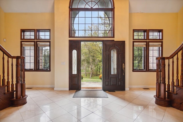 tiled entryway featuring a towering ceiling