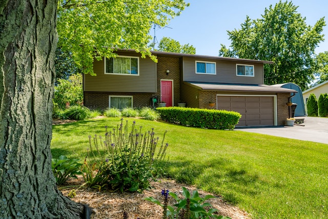 split foyer home with a front yard and a garage