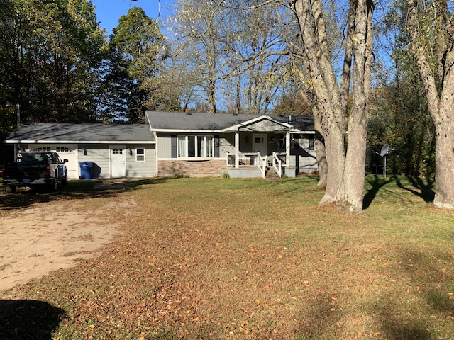 rear view of property featuring a garage and a lawn