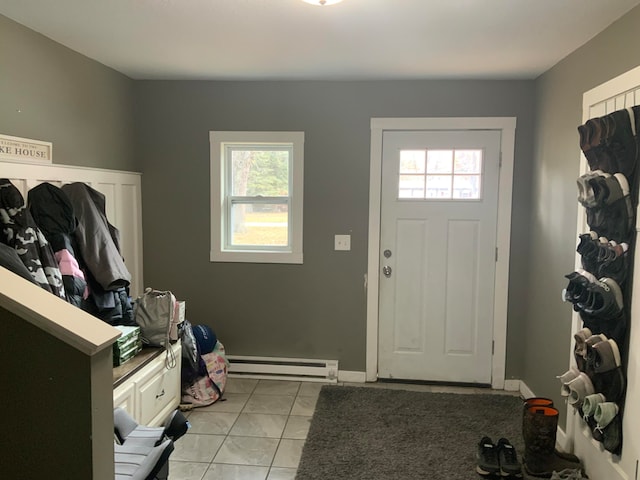 tiled entrance foyer featuring a baseboard heating unit and a healthy amount of sunlight