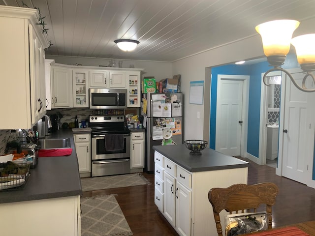 kitchen featuring dark wood-type flooring, stainless steel appliances, backsplash, sink, and white cabinets