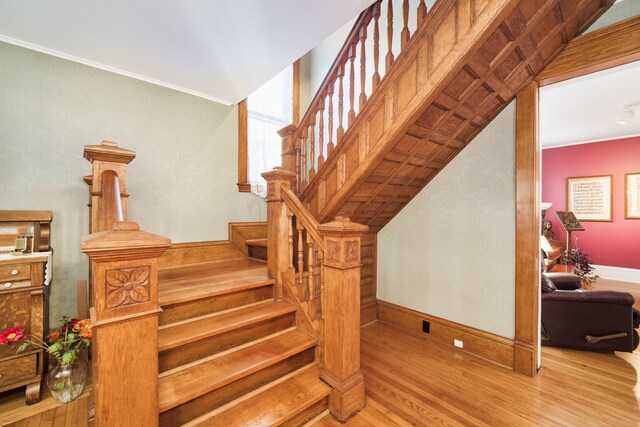 staircase featuring ornamental molding and hardwood / wood-style floors