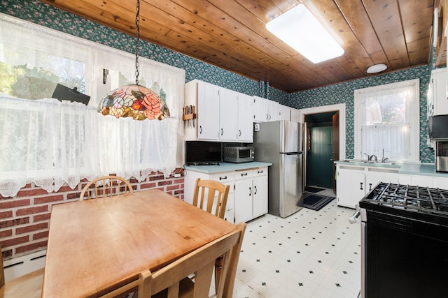 kitchen featuring black range, stainless steel fridge, pendant lighting, wood ceiling, and white cabinetry